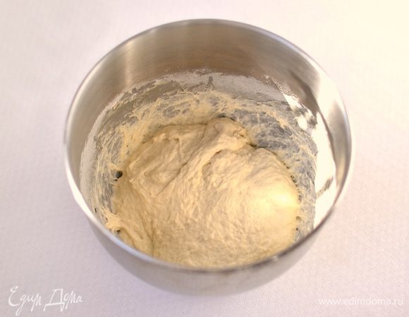 Готовим тесто.
В глубокую емкость кладем бигу (получается около 400-500 г биги), добавляем разведенные в 50 мл теплой воды 5 г сухих дрожжей, 100 мл воды комнатной температуры, сахар, соль, растительное масло, муку. Хорошо вымешиваем тесто (минимум 10-15 минут). Тесто липковатое. Вначале липнуть к рукам будет сильно, но по мере вымешивания оно станет отлипать от рук и рабочей поверхности. Лучше такое тесто месить в хлебопечке или тестомесе (через 7 минут оно начинает отлипать от стенок емкости и формироваться в шар вокруг крюка). 