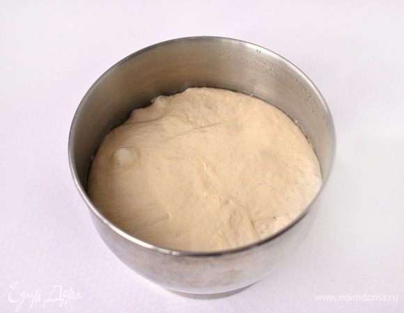 Емкость (смазать растительным маслом) с тестом накрыть пленкой, поставить в холодильник на 10 часов. Через 2 часа тесто обмять (в этой же емкости), как бы складывая его в конверт. Спустя 10 часов тесто достать из холодильника, дать ему согреться в течении 2 часов.
Разделить тесто на 2 части, постараться сформировать по форме посуды, в которой будете выпекать. Руки смазать растительным маслом, т.к. тесто липковато. Я выпекала в эмалированных мисках. Тесту придала форму шара, уложила в смазанную растительным маслом миску. Дать тесту расстояться в теплом месте 60-70 минут. Обязательно накрыть сверху или фольгой, смазанной растительным маслом, или пленкой.