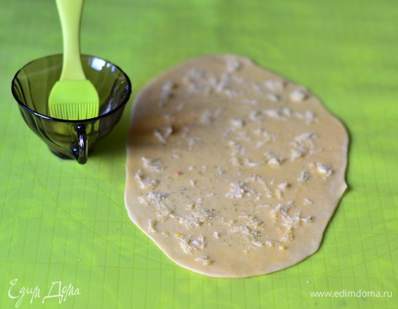 Чеснок выдавить через пресс или мелко порезать. Распределить по тесту.