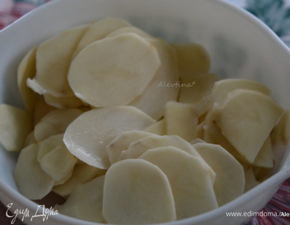 Разогреть духовку до 190°С. 
Смазать маслом овальное блюдо для запекания. Картофель нарезать тонко.