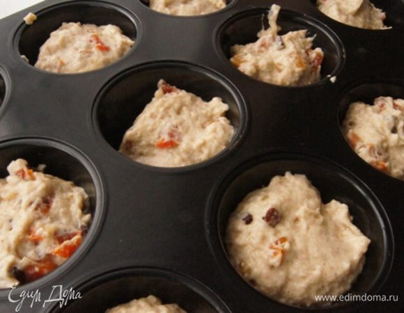 Формочки смазать растительным маслом, распределить тесто на 12 кексов.