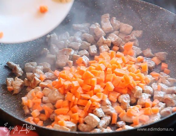 К мясу добавляем нарезанную кубиками морковь и обжариваем 2 минуты без крышки.