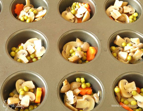 Дно формочек смазываем слегка маслом растительным. Раскладываем морковь, грибы, горошек — набор стандартный для знакомого с детства рецепта. Иногда хочется более простых рецептов, с малокомпонентным составом, минимум специй.