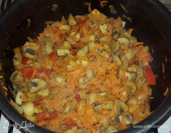В казане или кастрюле с антипригарным покрытием разогреваем немного масла и обжариваем нарезанные грибы до выпаривания жидкости. Добавляем к ним нарезанный на четверть кольца лук и обжариваем до мягкости и золотистого цвета.
Морковь натираем на крупной терке и отправляем к луку с грибами, перемешиваем, убавляем огонь и тушим 3 минуты. Помидоры нарезаем кубиками и отправляем к остальным, солим, перчим, добавляем тимьян и шафран, перемешиваем и тушим еще несколько минут.