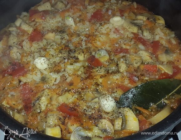 Когда рис разбух, втыкаем в него очищенный чеснок целыми зубчикам, немного солим, перчим, накрываем крышкой и даем еще немного потомиться.