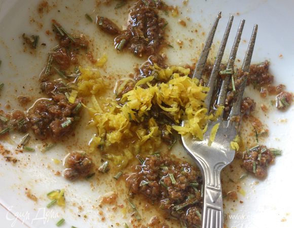 Размять филе анчоусов с маслом. Добавить порезанный розмарин, цедру и специи.