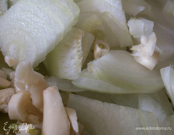 Лук нарезать полукольцами. Чеснок раздавить ножом и смешать с луком. Выложить на дно формы.