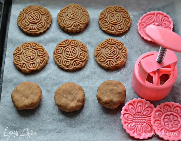 Разделите тесто на 16 частей, каждую скатайте в шарик и слегка приплющите руками. На противень, выстланный бумагой для выпекания, выложите заготовки. С помощью штампа для печенья сделайте рисунок и подправьте контур с помощью ножа или круглой вырубки. Если у вас нет штампа, то можно сделать оттиски, используя донышки стаканов, розеток.