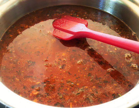 Добавьте вино, куриный бульон, сахар, оставшееся сливочное масло, доведите соус до кипения и кипятите на медленном огне минут 5. 