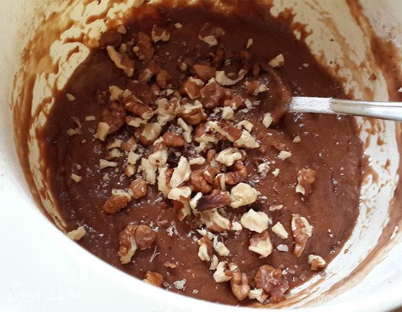 Орехи покрошить руками на крупные кусочки и перемешать с тестом.