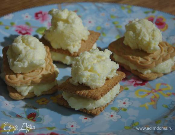 На одно печенье выложить 1‒2 ч. ложки застывшего мороженого и накрыть вторым печеньем.