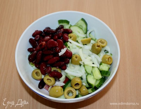 C фасоли слейте жидкость, лук нарежьте полукольцами, добавьте оливки.