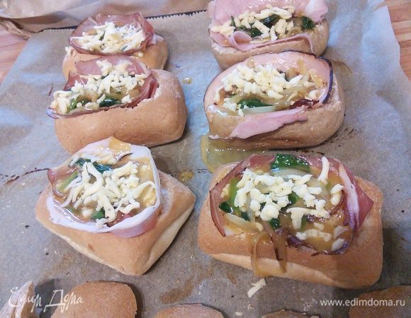 Яйца аккуратно поместить внутрь булочек. Посыпать сыром. 