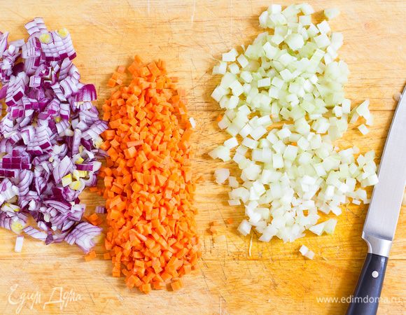 Лук нашинкуйте, морковь и сельдерей мелко нарежьте, затем чеснок раздавите.