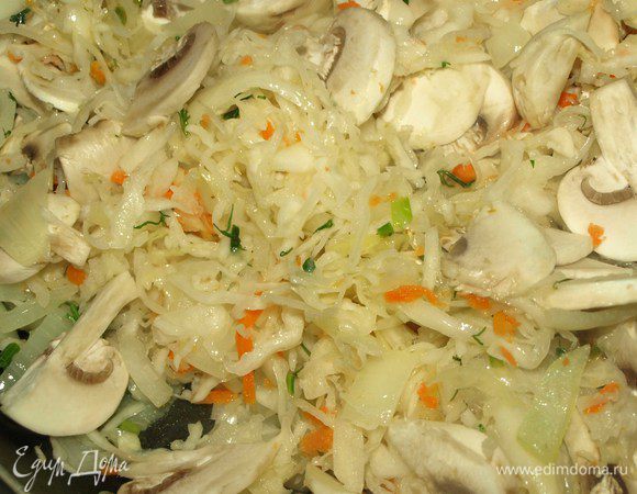 Добавляем к овощам отжатую от рассола квашеную капусту, нашинкованные пластинами грибы, закрываем крышкой и тушим на тихом огне. Пока капуста не станет мягкой.
