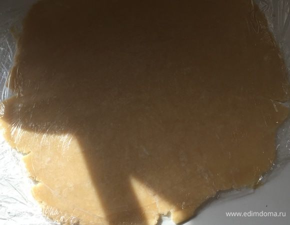 Когда тесто отдохнет, оно более податливое. Разогреваем духовку до 200°C. Разворачиваем тесто, накрываем вторым слоем пленки и раскатываем до 3-4 мм приблизительно.