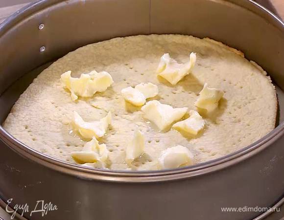 Оставшееся сливочное масло нарезать кусочками и выложить половину на подпеченный корж.