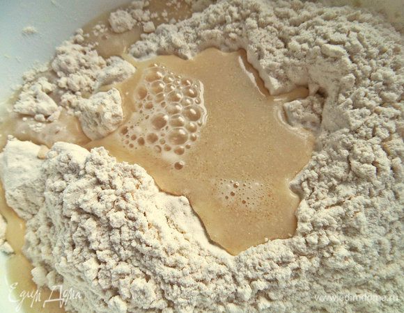 В просеянной муке сделать ямку и влить жидкость.