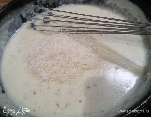 Влить сливки с молоком и не переставая помешивать, довести соус до кипения, проварить минуты 3, посолить (с учетом солености сыра), поперчить и добавить мускатный орех по вкусу. Вмешать половину натертого сыра.