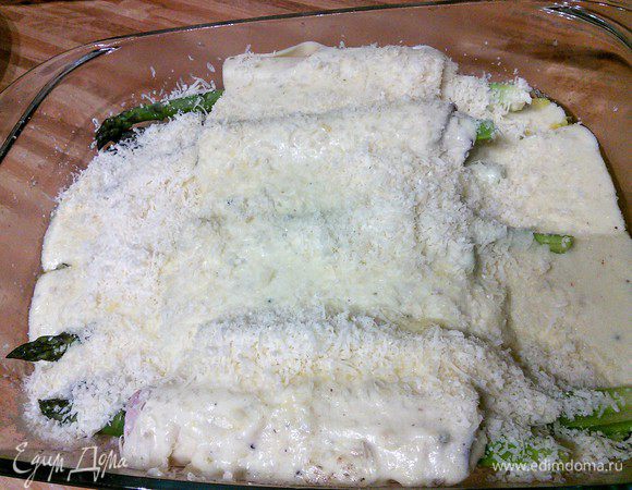 Залить рулеты соусом бешамель и посыпать оставшимся пармезаном.