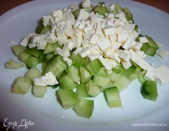 Очистить огурцы от кожицы, очистить от семян. Нарезать небольшими кубиками.
Фету нарезать небольшими кубиками, добавить к огурцам.