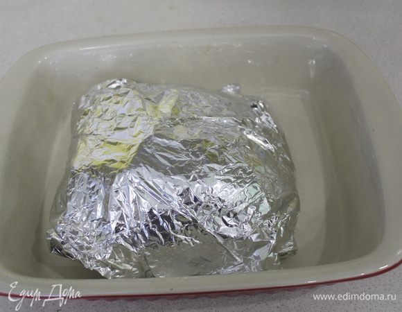 Завернуть плотно в фольгу. Запекать в предварительно разогретой до 180°C духовке 1,5 часа.