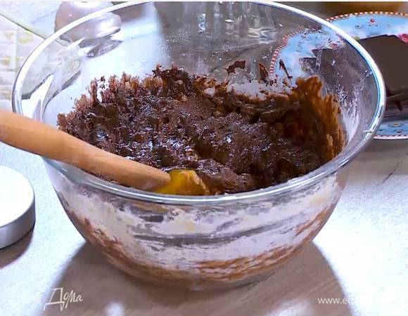 В яично-сахарную смесь добавить арахисовое масло, муку с разрыхлителем и измельченные орехи, все перемешать, затем влить растопленный шоколад и вымешать тесто.