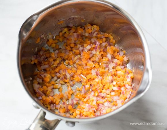 Разогрейте оливковое масло в большом сотейнике на среднем огне и обжаривайте на нем лук с морковью около 10 минут до мягкости.