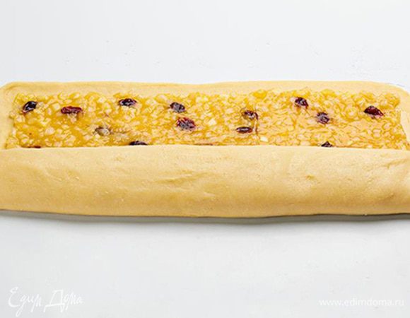 На слегка присыпанной мукой рабочей поверхности размять тесто и раскатать его в прямоугольник 40 на 30 см. Равномерно выложить начинку так, чтобы оставался отступ от краев около 2 см. Прямоугольник теста скатать с длинной стороны в рулон и разрезать на 8 одинаковых кусочков. 