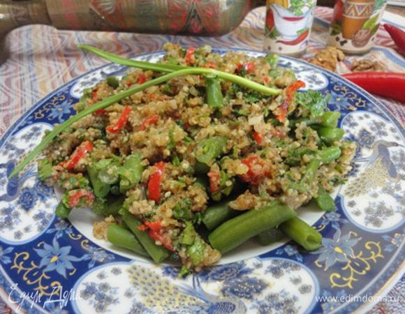 Вмешать все компоненты приправы — орехи, лук, специи, винный уксус, соль, мелко измельченный чеснок, зелень и все соединить с фасолью.