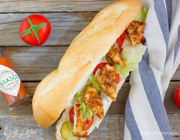 Надрежьте багеты вдоль и раскройте. Смажьте майонезом, выложите по несколько ломтиков помидоров, огурчика, салата айсберга. Добавьте ломтики курицы и подавайте, сбрызнув соусом табаско. Приятного аппетита!
