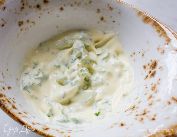 Приготовьте майонез: слегка взбейте желток с солью, перцем и уксусом, затем, не переставая взбивать, по немногу вливайте оливковое масло, пока не получиться густая однородная масса. Затем мелко порубите кинзу и петрушку, и добавьте к майонезу. 

