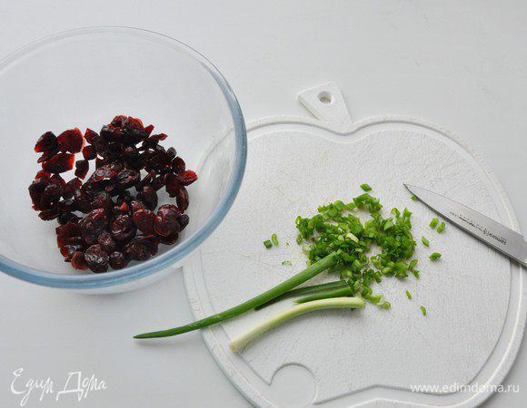 Вяленую клюкву промыть, обсушить. Перья зеленого лука мелко-мелко порезать.