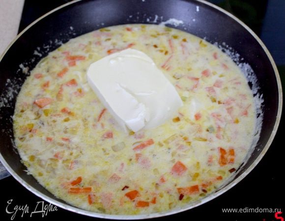 Добавить молоко, довести до начала кипения и добавить сливочный сыр. Готовить, помешивая, до расплавления сыра. Убавить огонь на минимум.