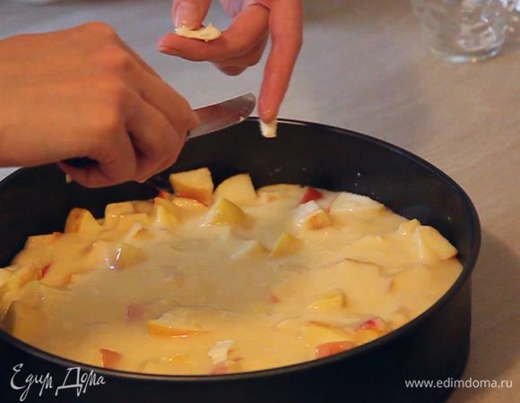 Сверху яблок выкладываем остаток теста. Разравниваем его. Произвольно кладем сверху теста маленькие кусочки сливочного масла.