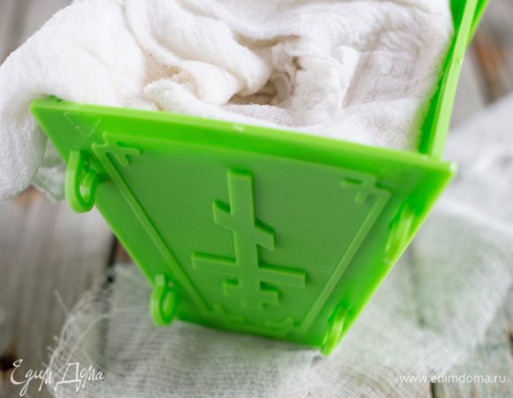 Форму для пасхи или сито выстелите двойным слоем марли, аккуратно влейте творожную массу и накройте краями марли, так чтобы сверху все было закрыто.