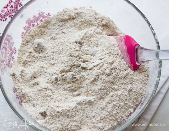 Слейте жидкость у вишни, ягоды сложите в миску вместе с мукой, корицей, какао, дрожжами, каплями шоколада, сахаром и 1 ч. л. мелкой соли. Тщательно перемешайте.