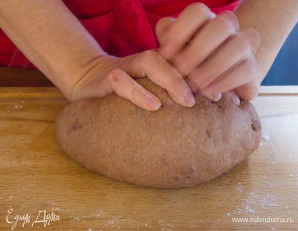 Два противня застелите пергаментом и смажьте маслом. Переложите тесто на присыпанную мукой поверхность и вымешивайте руками еще пару минут.