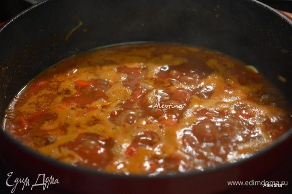 Добавить томаты баночные нарезанные кубиками, томатный соус и томатную пасту, вино и специи. Довести до кипения. Огонь убавить, закрыть крышкой и тушить 1,5 часа.