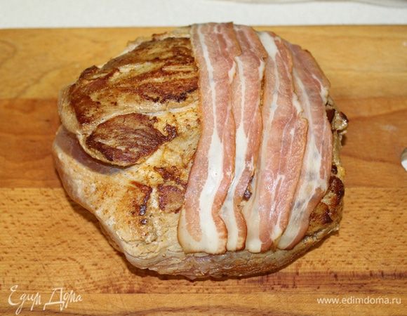 Перекладываем на разделочную доску. Сверху выкладываем полоски бекона.