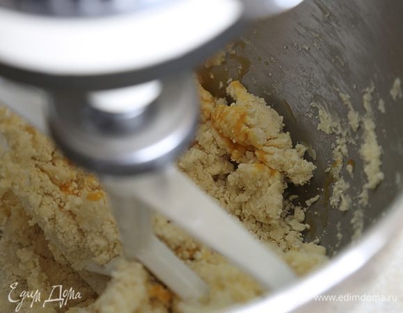 Порубить в крошку. Добавить желток и замесить тесто. Завернуть тесто в пленку, убрать на 1 час в холодильник.
