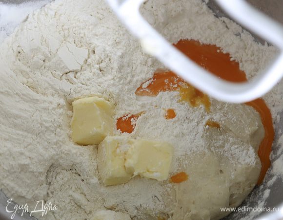 В миску с опарой добавить сливочное масло, желток, сахар, оставшуюся муку, соль, пряности. Хорошо вымесить тесто (5-6 минут в стационарном миксере).
