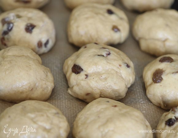 Подошедшее тесто разделить на небольшие шарики, выложить на противень, застеленный бумагой для выпечки. Накрыть салфеткой и оставить еще на 30 минут.

