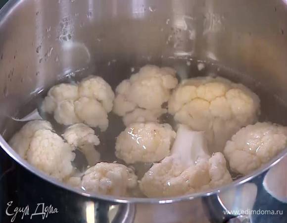 Цветную капусту разобрать на небольшие соцветия и опустить на 3‒4 минуты в кипящую воду.
