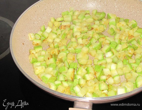Молодые цукини или кабачки, вымыть и нарезать средним кубиком. Разогреть в большой сковороде оливковое масло и обжарить кубики цукини до золотистого цвета. Цукини должны лежать в один слой. Если сковорода  небольшая, то цукини можно пожарить в два приема.