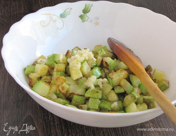 Готовый цукини выложить в миску, выдавить через чеснокодавилку 1 зубчик чеснока.