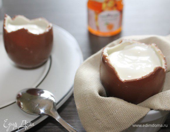 Готовим крем-наполнитель: в миске слегка взбиваем сливочный сыр с 2 ст.л. сахара. Продолжая взбивать, постепенно добавляем холодные сливки (в моем варианте это натуральный обезжиренный йогурт). "Крышечки" от яиц измельчаем. В яйцо, установленное на подставку, в которой оно будет подаваться на стол, выкладываем ложку крема, добавляем шоколадную крошку, и опять заполняем кремом, теперь уже практически до верха. 