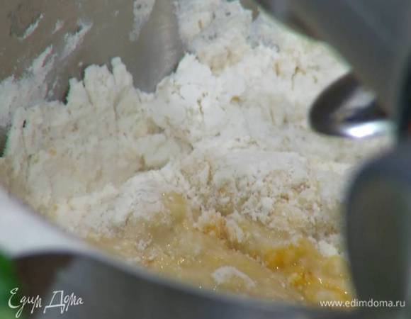 В чаше комбайна соединить 450 г муки, оставшийся коричневый сахар, соль и, вымешивая насадкой для теста на медленной скорости, тонкой струйкой влить молочно-дрожжевую смесь, затем, продолжая вымешивать, добавить яйца, желток и ванильный сахар.