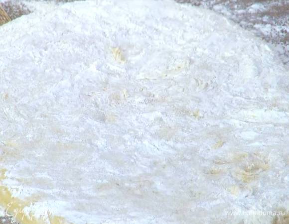 Рабочую поверхность посыпать половиной оставшейся муки, выложить тесто, сделать из него пласт, посыпать оставшейся мукой.