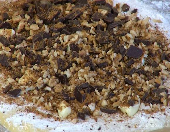 Порезать 50 г сливочного масла маленькими кусочками и поместить на тесто, сверху разложить орехи с шоколадом.